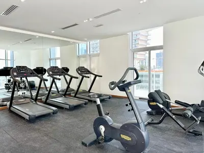 a gym with several treadms and cardio machines at Millenium Binghatti Residences Business Bay- Stylish Studio with Canal View in Dubai
