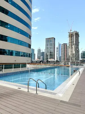a swimming pool with a city skyline in the background at Millenium Binghatti Residences Business Bay- Stylish Studio with Canal View in Dubai
