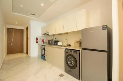 a kitchen with a refrigerator and a dishwasher at Millenium Binghatti Residences Business Bay- Stylish Studio with Canal View in Dubai