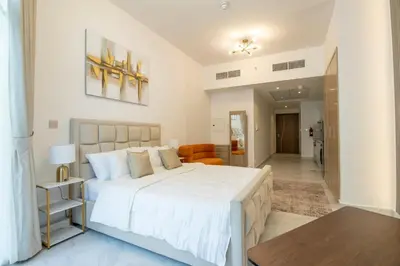 a bedroom with a large white bed and a living room at Millenium Binghatti Residences Business Bay- Stylish Studio with Canal View in Dubai