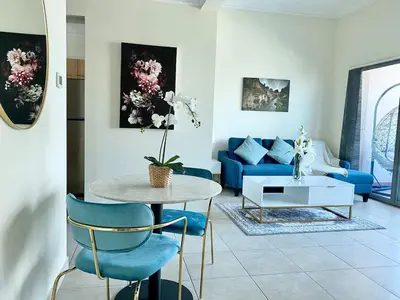 a living room with a table and a blue couch at ONE Bedroom with Sea view in Dubai Marina - Z1106 in Dubai