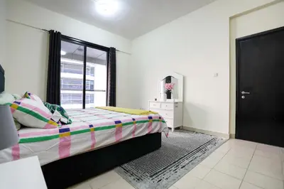 a bedroom with a large bed and a window at LUXURY 1BED MARINA VIEW JBR BEACH POoL PARKING in Dubai