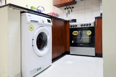 a kitchen with a washing machine and a stove at LUXURY 1BED MARINA VIEW JBR BEACH POoL PARKING in Dubai