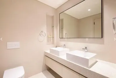 a white bathroom with two sinks and a mirror at شقة مع منظر رائع in Dubai