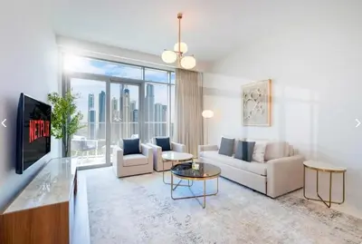 a living room with white furniture and a large window at شقة مع منظر رائع in Dubai