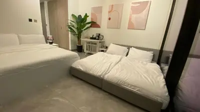 a bedroom with two beds and a plant at Sky Burj Khalifa View in Dubai