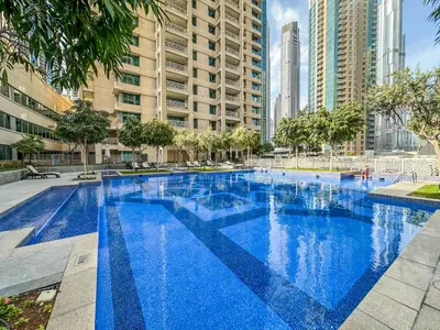 a large blue swimming pool with tall buildings at Lux Burj and Fountain views Steps from Dubai Mall in Dubai