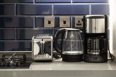 a kitchen counter with a coffee maker and affeepot at Chic Studio 5 Min Walk to Dubai Mall & Burj in Dubai