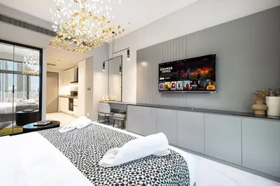 a bedroom with a bed and a tv on the wall at Chic Studio 5 Min Walk to Dubai Mall & Burj in Dubai