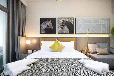 a bedroom with a bed and two paintings on the wall at Chic Studio 5 Min Walk to Dubai Mall & Burj in Dubai