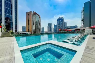 a large swimming pool with a city skyline in the background at Chic Studio 5 Min Walk to Dubai Mall & Burj in Dubai