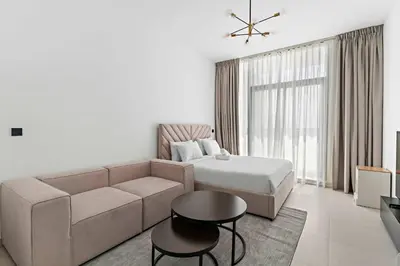 a living room with a couch and a bed at Modern Studio in Al Furjan with pool and gym in Dubai