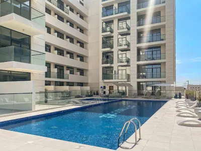 a swimming pool in front of a building at Modern Studio in Al Furjan with pool and gym in Dubai