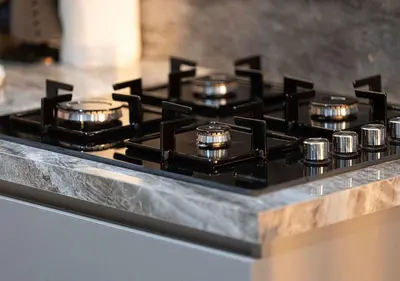 a stove top with several pots on top of it at Chic 1-Bed Apartment with Exclusive Amenities JVC in Dubai