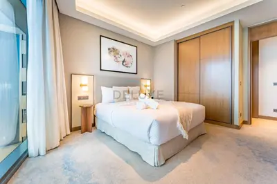 a bedroom with a large white bed and a window at Overlooking Burj Khalifa and Fountain Views from Living to Bedrooms, The Address Residences Dubai Opera Tower 2, Downtown Dubai by Deluxe Holiday Homes in Dubai