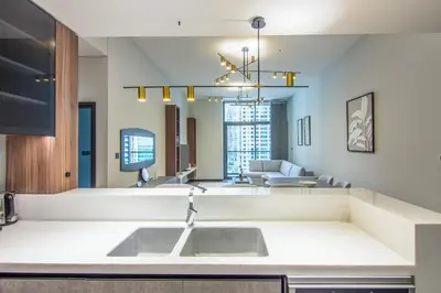 a kitchen with a sink and a living room at MBL Royal, JLT- Two Bedroom with Lake View in Dubai