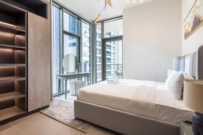 a bedroom with a bed and a large window at MBL Royal, JLT- Two Bedroom with Lake View in Dubai