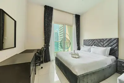 a bedroom with a bed and a desk and a window at Modern Studio Retreat in Sports City Dubai in Dubai