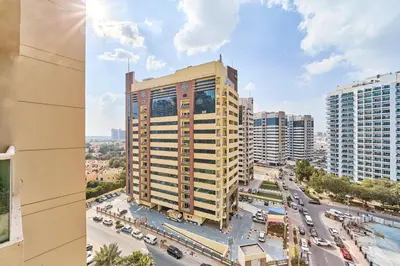 a tall building and a street with cars in a city at Modern Studio Retreat in Sports City Dubai in Dubai
