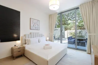 a bedroom with a white bed and a large window at Livbnb-Tranquil Family Home, 4BR with Maid's Room in Dubai