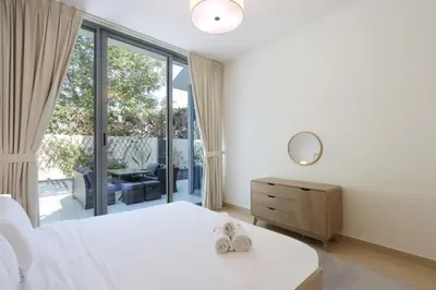 a bedroom with a white bed and a large window at Livbnb-Tranquil Family Home, 4BR with Maid's Room in Dubai