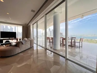a living room with large windows and a table with chairs at Daniels 4BR at Five Palm With Private Pool in Dubai