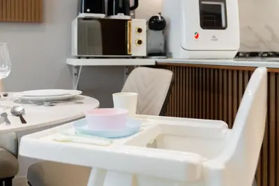 a kitchen with a white table with dishes on it at SettlerHomes - Chic JVC Cityview Near Heart of Dubai in Dubai