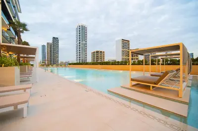 a swimming pool with a lounge chair on a building at SettlerHomes - Chic JVC Cityview Near Heart of Dubai in Dubai
