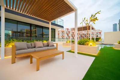 a patio with a couch on the roof of a building at SettlerHomes - Chic JVC Cityview Near Heart of Dubai in Dubai