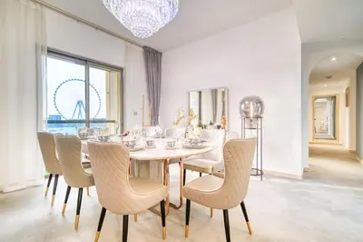 a dining room with a white table and chairs at THE JBR Grand Luxury Sea View 4 BEDROOM in Dubai