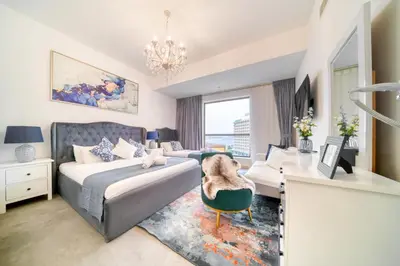a bedroom with a bed and a desk with a chair at THE JBR Grand Luxury Sea View 4 BEDROOM in Dubai