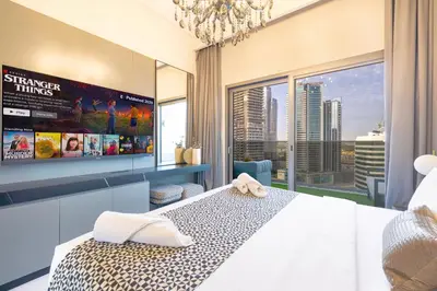 a bedroom with a bed and a large window at Upscale 2BR in Lively Building in Dubai