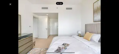 a bedroom with a large white bed and a television at Downtown holiday home in Dubai