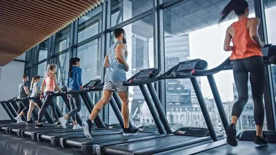 a group of people running on treadmills in a gym at Cozy Studio Steps from Dubai Mall & Burj Khalifa in Dubai