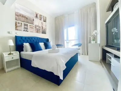a blue and white bedroom with a bed and a tv at Cozy Studio Dubai Marina by beach & Metro Z1503 in Dubai