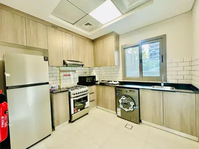 a kitchen with a refrigerator and a sink at Bab al qarya in Dubai