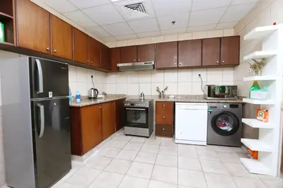 a kitchen with a refrigerator and a dishwasher at Marina Haven with Jacuzzi in Dubai
