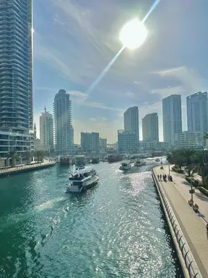 a boat in a river in a city with buildings at Marina Haven with Jacuzzi in Dubai