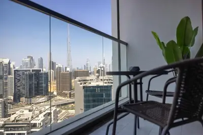 a chair on a balcony with a view of a city at Studio in downtown with Burj Khalifa and city view in Dubai