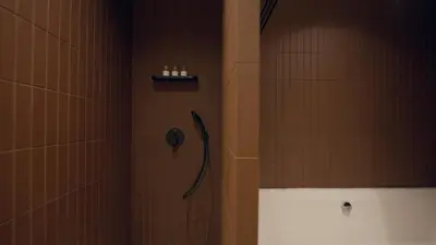 a shower in a bathroom with a phone on the wall at Mori - luxury Burj full view in Dubai