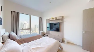 a white bedroom with a bed and a tv at Best 2 bedroom Direct Burj Khalifa Downtown View in Dubai