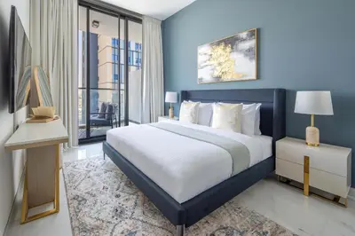 a blue bedroom with a large bed and a window at Frank Porter - Samana Park Views in Dubai
