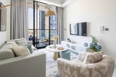a living room with a couch and chairs and a tv at Frank Porter - Samana Park Views in Dubai