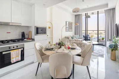 a kitchen and living room with a table and chairs at Frank Porter - Samana Park Views in Dubai
