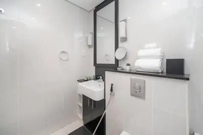 a white bathroom with a sink and a mirror at Cozy and elegant Studio in Business Bay in Dubai