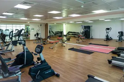 a gym with many treadmills and exercise bikes at Waves - Charming Apt With Balcony Steps From The Beach in Dubai