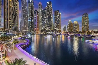 a view of a city at night with boats in the water at FIRST CLASS 1BR Inviting Marina Views in Dubai