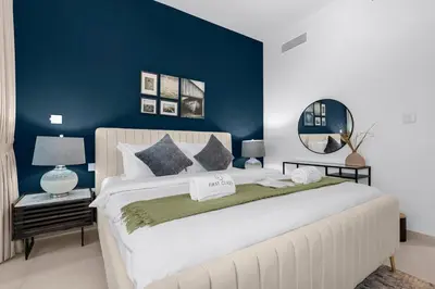 a bedroom with a large white bed with a blue wall at Elegant 1BR in Heart of Dubai, Walk to Top Malls in Dubai