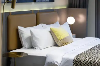 a bedroom with a bed with white pillows and a table at Luxury Studio Near Dubai Mall few mints walk in Dubai