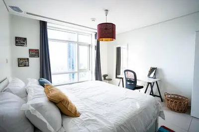a bedroom with a white bed with a large window at The Lofts West Downtown - 2 Minutes Walk to Burj Khalifa-Dubai Mall 1BDR in Dubai